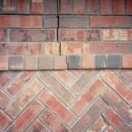 Cracks in bricks are common signs of foundation movement, as seen in this photo.
