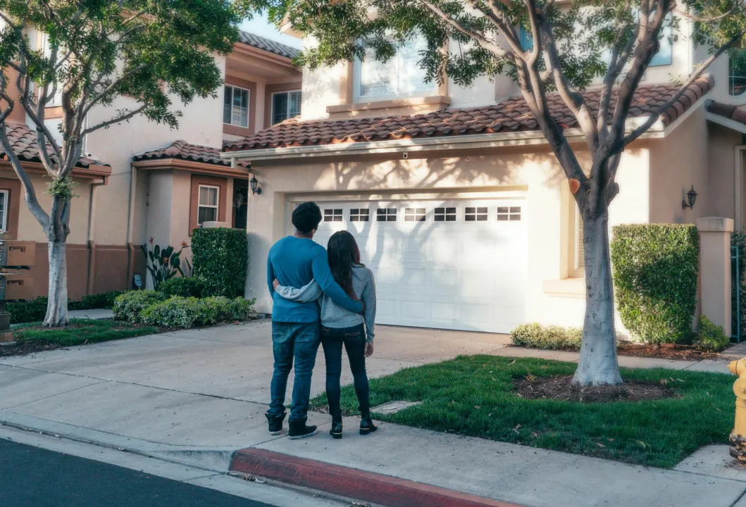 a couple standing before a house a couple standing before a house