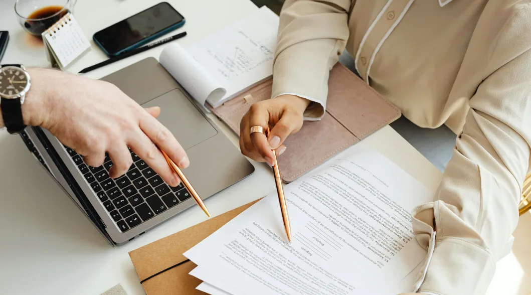 people reading business documents and holding pen people reading business documents and holding pen