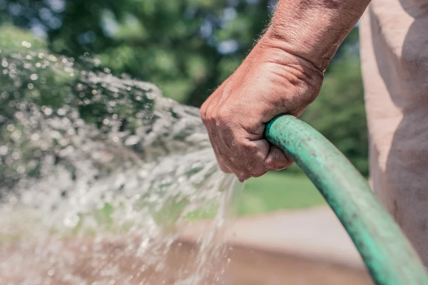 Man holding a water hose Man holding a water hose