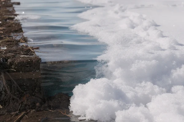 water pooling in the soil beneath melting snow water pooling in the soil beneath melting snow