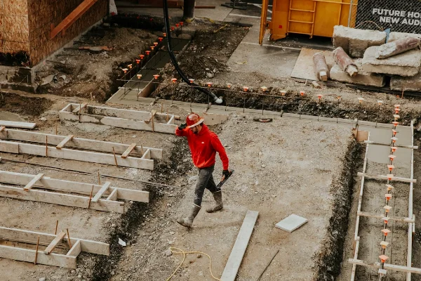 man in red jacket and black pants walking on gray concrete stairs man in red jacket and black pants walking on gray concrete stairs